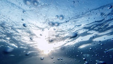 Foto de Burbujas de aire que se mueven desde el fondo del mar hasta la superficie del agua, con el efecto calmante de la luz solar. Ideal para un fondo abstracto. - Imagen libre de derechos