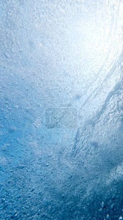 Téléchargez les photos : Beaucoup de petites bulles d'air montant à la surface de la mer en eau bleue claire. - en image libre de droit