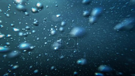 Foto de Las burbujas de aire se elevan desde el fondo del mar hasta la superficie del agua, bellamente iluminadas por la luz del sol. Ideal para un fondo natural abstracto. - Imagen libre de derechos