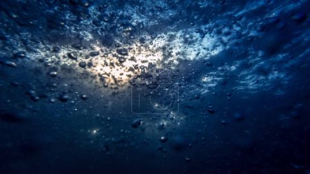 Foto de Las burbujas de aire ascienden del lecho marino a la superficie del agua, complementadas por la exhalación de un buceador. Perfecto para crear un fondo abstracto y tranquilo. - Imagen libre de derechos
