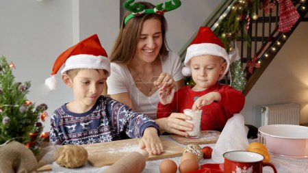 Photo for Portrait of happy cheerful family with kids cooking on kitchen and preparing for Christmas and New Year celebrations. - Royalty Free Image