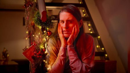 Téléchargez les photos : Portrait de femme effrayée et nerveuse la nuit de Noël attendant l'arrivée de la police. Criminalité, problèmes avec la loi et vol pendant les vacances et les célébrations d'hiver - en image libre de droit