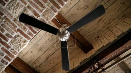 Téléchargez les photos : Ventilateur d'air de plafond tournant lentement sur le vieux plafond antique en bois et brique. - en image libre de droit