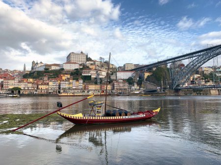 Foto de Un barco rojo en el río Doru con los edificios en el fondo en Oporto, Portugal - Imagen libre de derechos