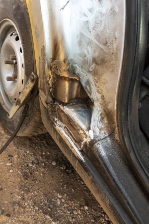 el coche plateado tiene un agujero en la puerta debido a la vejez y la mala atención. reparación.