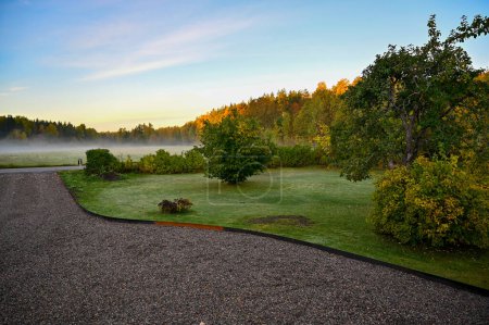 Frühmorgens Nebel über Garten mit Schotterpiste Kumla Schweden 4. Oktober 2022