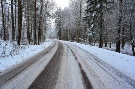 Téléchargez les photos : Route enneigée et glissante à travers la forêt près de Kumla Suède 5 décembre 2022 - en image libre de droit