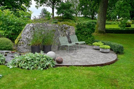 Deux chaises en métal debout ner grande pierre dans le jardin Suède 12 août 2023