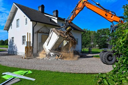 Photo for Big orange excavator demolishing part of house in Kumla Sweden august 15 2023 - Royalty Free Image