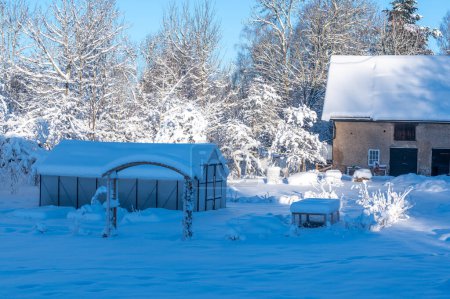 Téléchargez les photos : Grange et serre une journée d'hiver froide et enneigée Kumla Suède 27 décembre 2023 - en image libre de droit