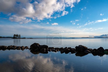 Blick auf kleine Steinmole am ruhigen See Motala Schweden 26. April 2024