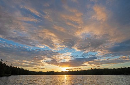 Téléchargez les photos : Le soleil se couche au milieu de nuages élevés sur le lac Jenny dans les eaux limitrophes dans le Minnesota - en image libre de droit