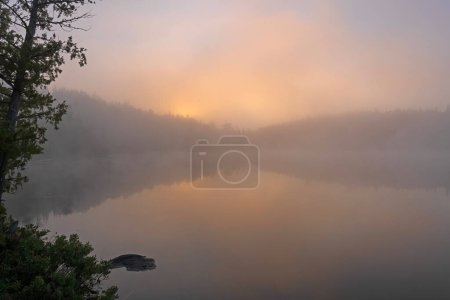 Téléchargez les photos : Brouillard matinal alors que le soleil émerge sur le lac Jenny dans la région des eaux limitrophes Canot dans le Minnesota - en image libre de droit