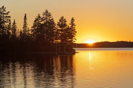 Téléchargez les photos : Ciel orange dans les bois du Grand Nord sur le lac Kekekabic dans la région des eaux limitrophes Canot dans le Minnesota - en image libre de droit