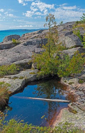 Estanque minúsculo en una costa rocosa de los Grandes Lagos en el Parque Provincial Neys en Ontario
