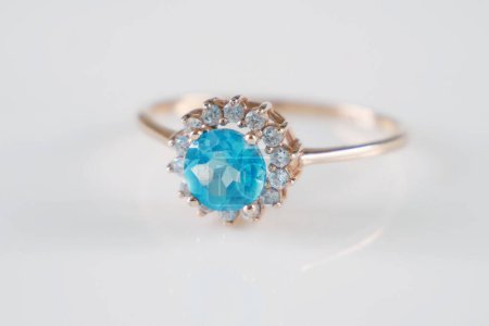 Foto de Hermoso anillo con topacio azul y muchos diamantes blancos sobre fondo blanco, primer plano - Imagen libre de derechos