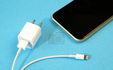 Foto de Using USB TYPE C Port Cable for mobile phone charger on blue background, charger cable, closeup - Imagen libre de derechos