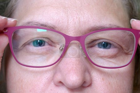 Foto de Middle-aged woman wearing glasses with pupils dilated of eyes, face woman in glasses, closeup, macro - Imagen libre de derechos