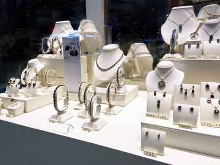 Tienda de joyería, anillos de joyería y collares con piedras muestran en la exhibición de escaparates de tiendas minoristas de lujo, primer plano