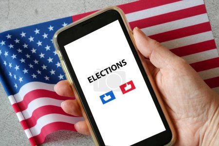 Foto de Bandera americana y teléfono móvil en la mano, demócratas o republicanos? Primarias en Estados Unidos, elecciones 2023 - 2024 concepto, primer plano - Imagen libre de derechos