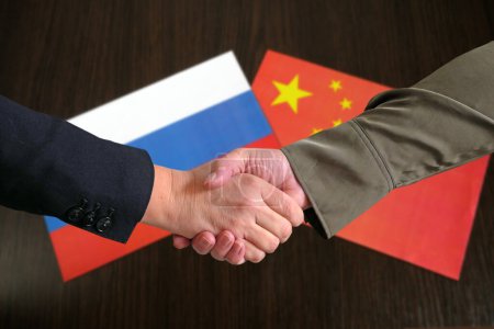 Téléchargez les photos : Poignée de main dans le contexte de la Russie et de la Chine, amitié et partenariat de deux pays concept, gros plan - en image libre de droit