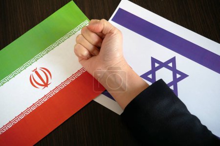 Téléchargez les photos : Les doigts serrés dans un poing sur le fond des drapeaux d'Israël et d'Iran, la confrontation entre les deux pays après le bombardement d'Israël par le Hamas, concept, gros plan - en image libre de droit
