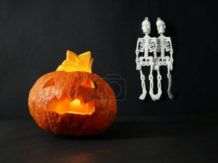 Foto de Divertidos esqueletos de halloween feliz y calabaza Jack O Linterna sobre fondo negro. Tarjeta de felicitación de Halloween, invitación a la fiesta de Halloween, el día de los Muertos, primer plano - Imagen libre de derechos