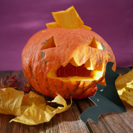 Foto de Calabaza de halloween Jack O Linterna, murciélagos y hojas de otoño. Tarjeta de felicitación de Halloween, invitación a la fiesta de Halloween, el día de los Muertos, primer plano - Imagen libre de derechos