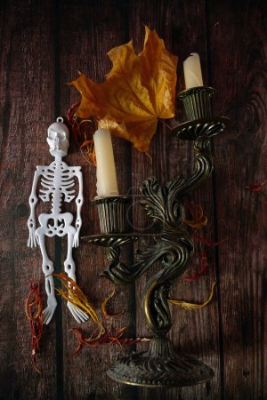 Foto de Esqueletos, murciélagos y hojas de otoño y candelabro con velas. Tarjeta de felicitación de Halloween, invitación a la fiesta de Halloween, el día de los Muertos, primer plano - Imagen libre de derechos