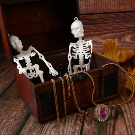 Foto de Esqueletos de Halloween en el cofre de madera con tesoros ocultos. Tarjeta de felicitación de Halloween, invitación a la fiesta de Halloween, el día de los Muertos, primer plano - Imagen libre de derechos
