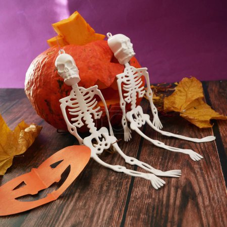 Foto de Divertidos esqueletos de halloween feliz, murciélagos y calabaza Jack O Linterna sobre fondo de madera oscura. Tarjeta de felicitación de Halloween, invitación a la fiesta de Halloween, el día de los Muertos, primer plano - Imagen libre de derechos