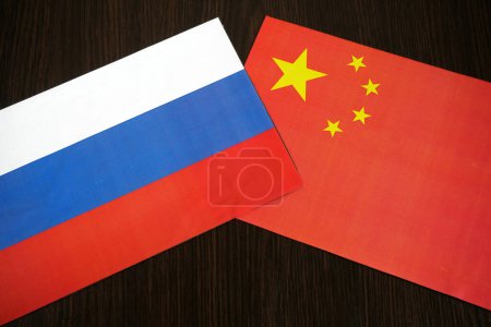 Téléchargez les photos : Deux drapeaux de la Chine et de la Fédération de Russie sur fond en bois noir, signe et symboles, concept, gros plan - en image libre de droit