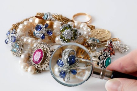 Foto de Muchas joyas de oro y plata y lupa, concepto de tienda de empeño, concepto de joyería - Imagen libre de derechos