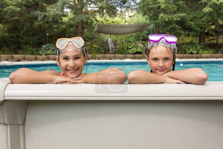 Téléchargez les photos : Deux jeunes filles portent des lunettes et sourient à la caméra. Ils sont dans une piscine et semblent s'amuser - en image libre de droit