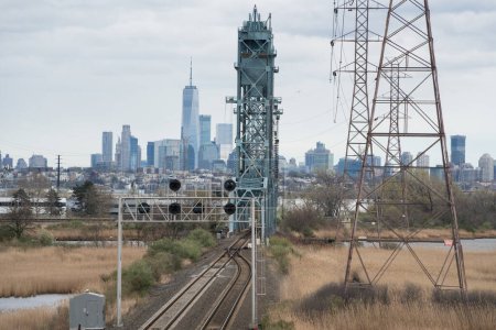Téléchargez les photos : Les voies ferrées mènent au front de mer du New York New Jersey par une journée nuageuse - en image libre de droit
