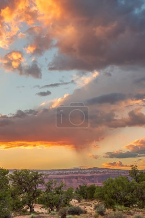 Téléchargez les photos : Un beau coucher de soleil sur une chaîne de montagnes avec quelques nuages dans le ciel. Le ciel est un mélange de teintes orange et rose, créant une atmosphère chaleureuse et sereine - en image libre de droit