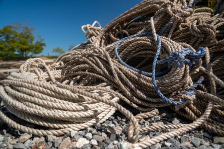 Téléchargez les photos : Bobines de corde étendu sur le sol près du port dans le Maine par une journée bleu vif - en image libre de droit