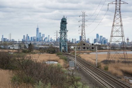 Téléchargez les photos : Les voies ferrées mènent au front de mer du New York New Jersey par une journée nuageuse - en image libre de droit