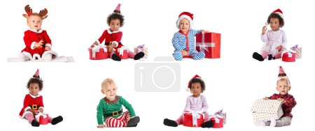 Foto de Conjunto de bebés lindos en trajes de Navidad, con sombreros y regalos de Papá Noel sobre fondo blanco - Imagen libre de derechos