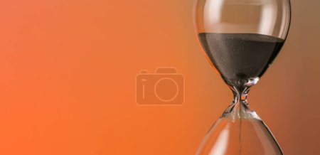Photo for Hourglass on orange background with space for text, closeup - Royalty Free Image