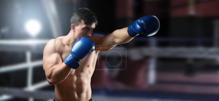 Foto de Entrenamiento de boxeador musculoso joven en gimnasio - Imagen libre de derechos