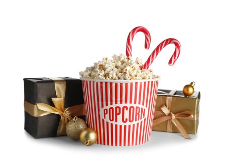 Photo for Bucket of popcorn with candy canes, Christmas balls and presents on white background - Royalty Free Image