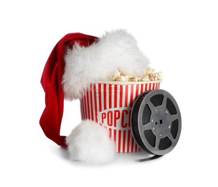 Eimer Popcorn mit Weihnachtsmütze und Filmrolle auf weißem Hintergrund