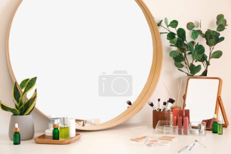Photo for Different cosmetic products, makeup brushes and mirror on table - Royalty Free Image