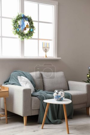 Photo for Interior of living room with sofa and window decorated for Hanukkah celebration - Royalty Free Image