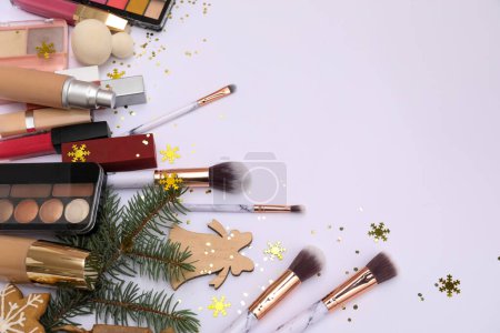 Téléchargez les photos : Produits de maquillage avec branches de Noël sur fond blanc - en image libre de droit