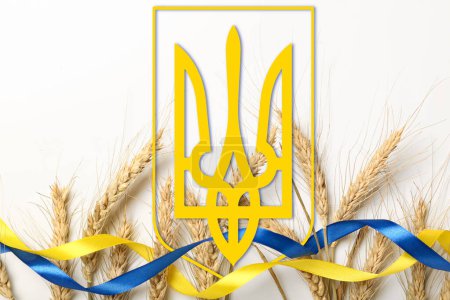 Foto de Espiguillas de trigo, tridente y cintas en colores de bandera ucraniana sobre fondo blanco - Imagen libre de derechos
