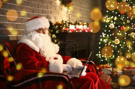 Foto de Papá Noel con portátil en casa en la víspera de Navidad - Imagen libre de derechos