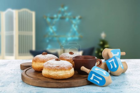 Photo for Donuts and dreidels for Hanukkah on table in room - Royalty Free Image