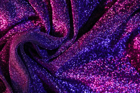 Shiny purple fabric in neon light as background